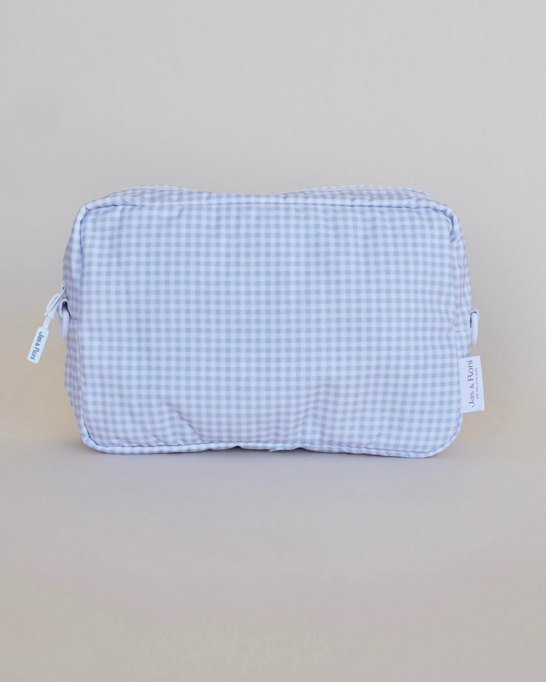 Bolsa neceser a cuadros azules en fondo beige