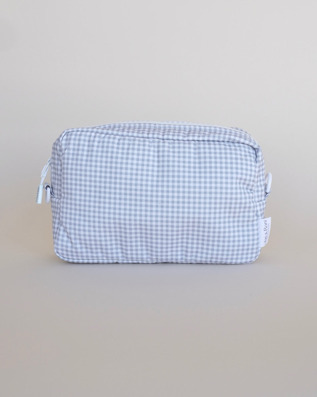 Bolsa neceser a cuadros grises en fondo beige