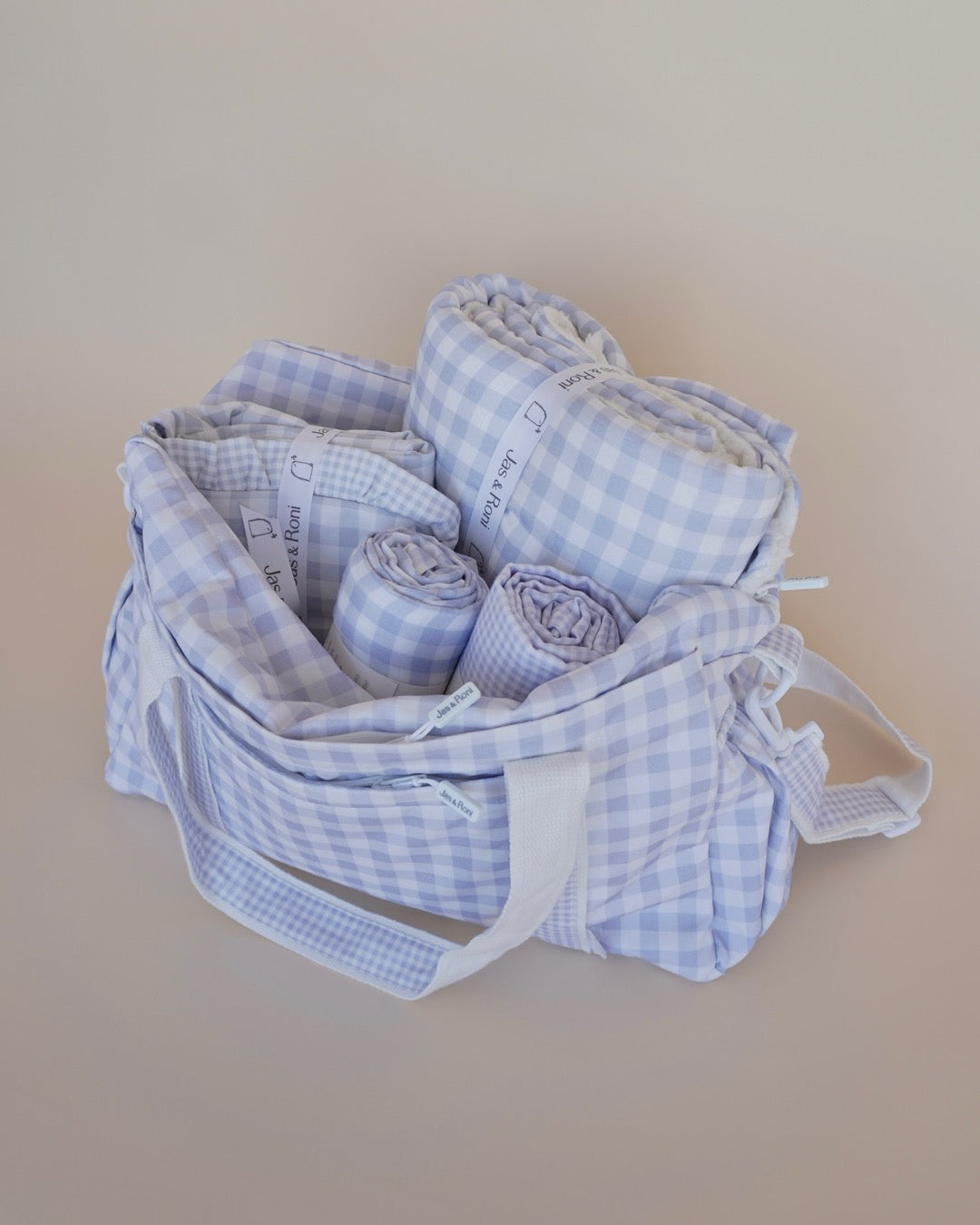 Pañalera de tela estampada en cuadros azules en fondo crema