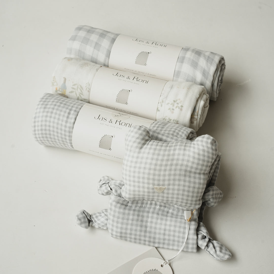 Set de tres muselinas y animalito de tela en diversos estampados sobre fondo beige