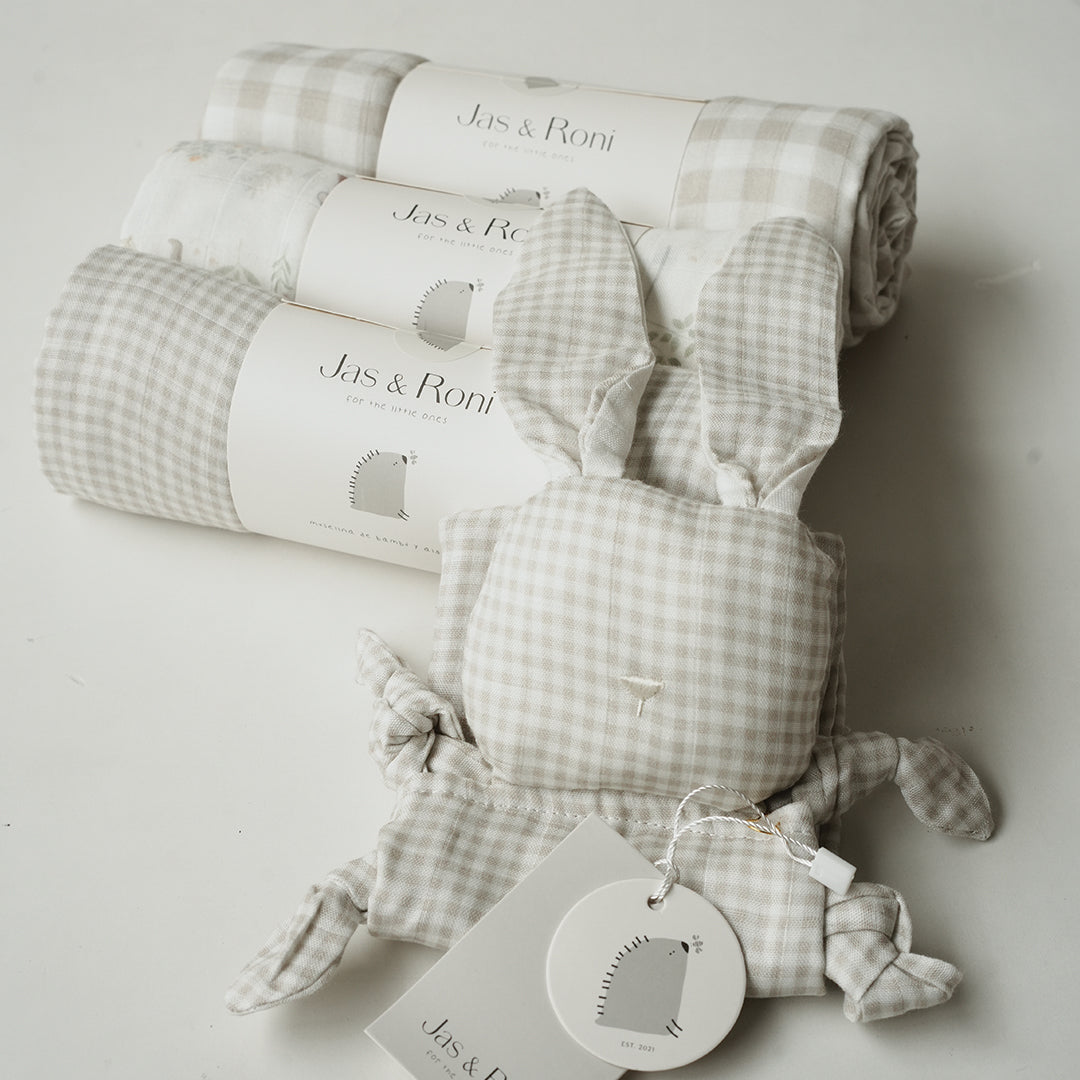 Set de tres muselinas y conejito de tela en diversos estampados sobre fondo beige