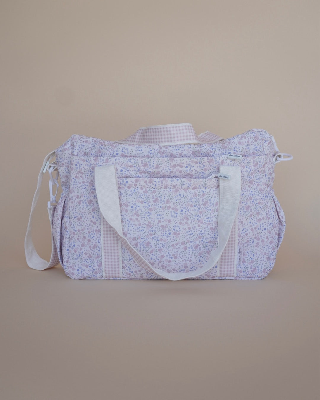 Pañalera de tela estampada en flores azules y rosas en fondo crema