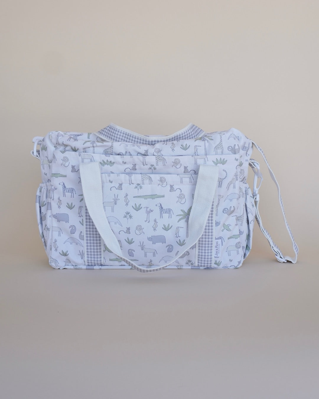 Pañalera de tela estampado safari y cuadros grises en fondo crema